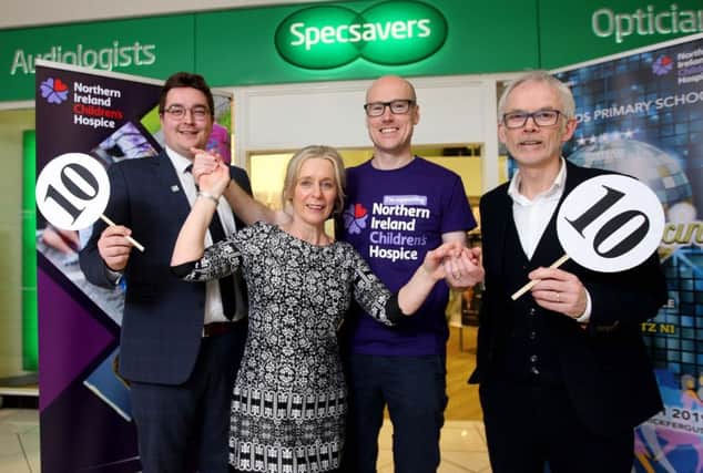 Heather Lewis gets into training for Sunnylands does Strictly with Johnny Breen, Childrens Hospice regional fundraiser and receives top marks from Tony McGinn (right), Specsavers optometry director and Darryl Marshall, store manager.