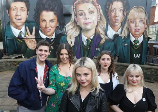 Derry Girls creator Lisa McGee, second from left, with cast members Dylan Llewellyn , Saoirse-Monica Jackson, Louisa Harland and Nicola Coughlan when they visited the 'Derry Girls' mural painted by UV Artists on the gable wall of Badger's Bar, Derry. The second series of the hit show is coming soon to Channel 4.