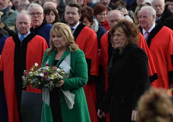 Kate Carroll (widow of Steve Carroll) lays a wreath with Yvonne Black (widow of David Black) during a memorial service in Antrim this week.