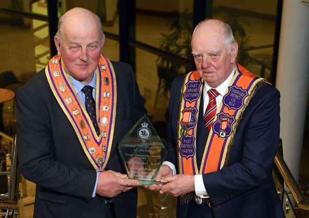 Sidney McIldoon (right) receives the Grand Master's lifetime achievement award from senior Orangeman, Edward Stevenson.