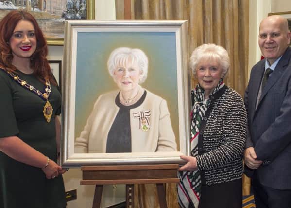 Joan Christie is presented with a portrait by the Mayor of Mid and East Antrim, Councillor Lindsay Millar and Councillor Paul Reid.