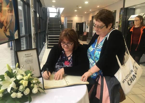 Marie ONeill (right) and her friend, Siobhan, sign the Cookstown book of condolence for the families of three teenagers who died on Sunday
