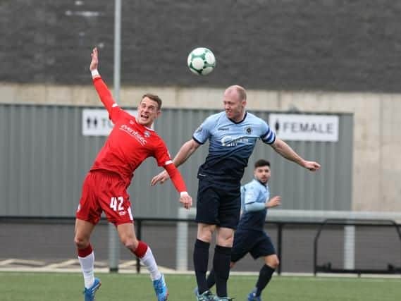 Institute's Dean Curry out jumps Coleraine's Dean Shiels to win this header. Picture by Kevin Moore