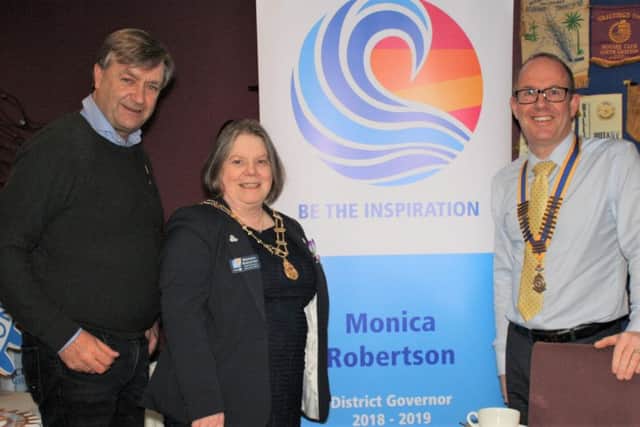 District Governor-elect William Cross (left) and Michael Thompson, President of the Rotary Club of Larne, welcome District Governor Monica Robertson on the occasion of the club's 75th anniversary.