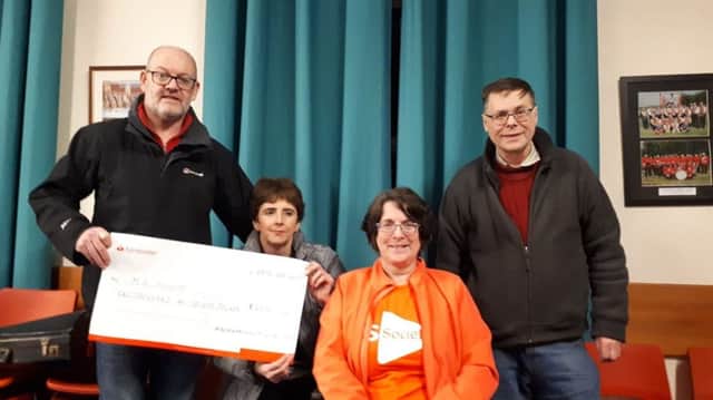 Jeff Duff, secretary and Randal McDowell, treasurer, Magheramorne Silver Band, present Multiple Sclerosis Society representatives Wendy Trew and Caroline Millar with a cheque for £2030.
