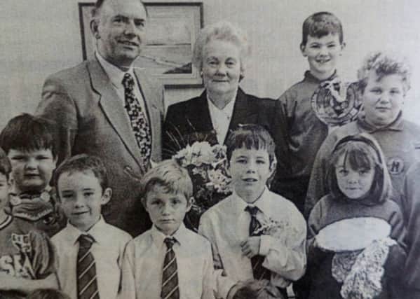 May McRoberts, who has retired after 28 years' service at Ballyclare Primary School, pictured with principal Winston Pollock and pupils who presented her with gifts. 1997