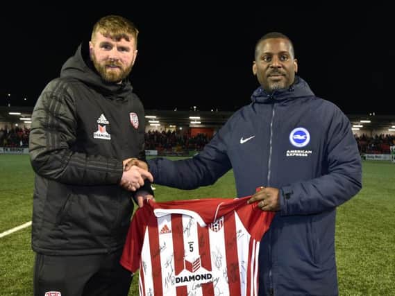 Paddy McCourt presenting a signed Derry City shirt to Brighton  Hove Albion coache Stu Lawrence at the Brandywell on Friday night. DER1419-109KM