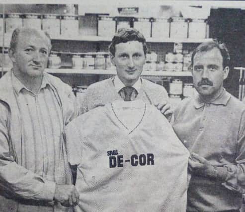 S. McGill (centre) of the De-Cor, William Street, Ballymena, hands over a new playing strip to Mr I Burnside and Mr D. Kidd of North End Football Club. 1989.