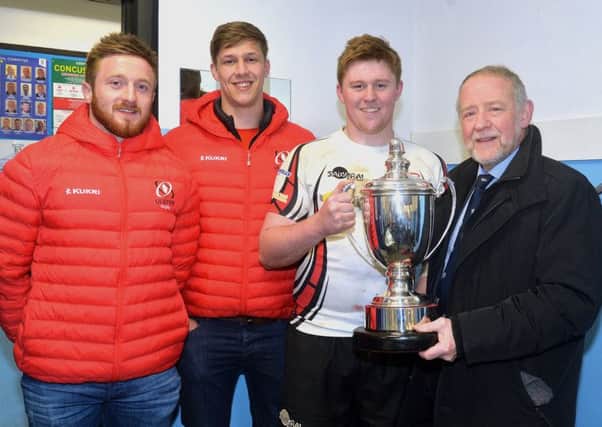 Armagh captain, Aaron Whyte receives the trophy from Brian Irwin, chairman of the tournament sponsors, Irwin's Bakery. Also included are Ulster payers David Busby, left, and Caleb Montgomery.