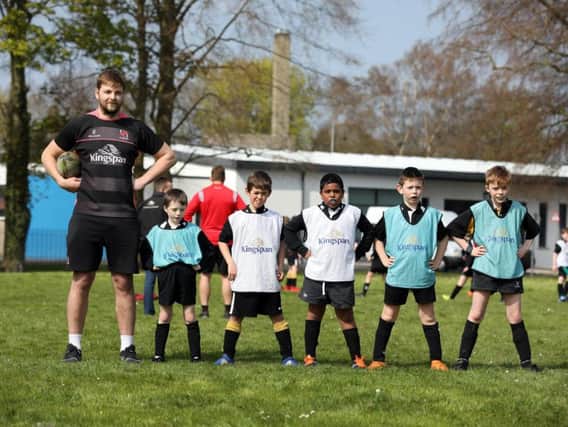 Edenderry Primary pupils size up to Ulster star Iain Henderson during a Kingspan Coaching Masterclass at the Portadown school