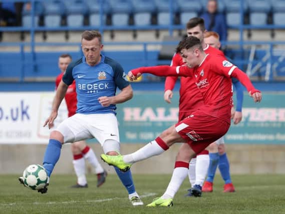 Coleraine's Ben Doherty tries his luck as Glenavon's Sammy Clingan closes him down