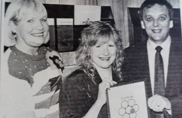 Joan Carleton, Cancer Research Campaign, and Dennis Irwin (chair of the Carrick Committee for the Campaign) present a bronze certificate of appreciation to Dawn Irsin for her work on behalf of the Committee. 1991