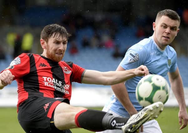 Howard Beverland hooks clear under pressure from Ballymena United's Shane McGinty during the weekend win for Crusaders. Pic by INPHO.