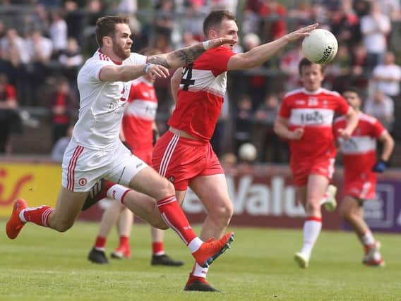 Derry's Ryan Bell tries to escape the clutches of Tyrone's Ronan mcNamee in Healy Park.