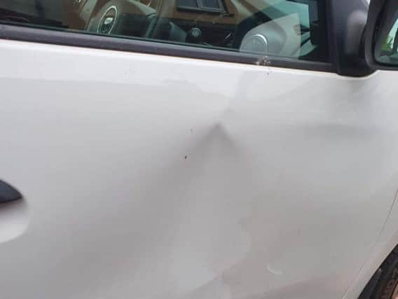 A parked car had its driver door dented.