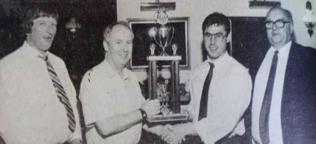 Tom Young of Penarol FC receives the club's leading goalscorer award from secretary of the Ballymena and District Saturday Morning League, Brian Montgomery, at their annual dinner as Hugo Colgan and John Leetch look on. 1989
