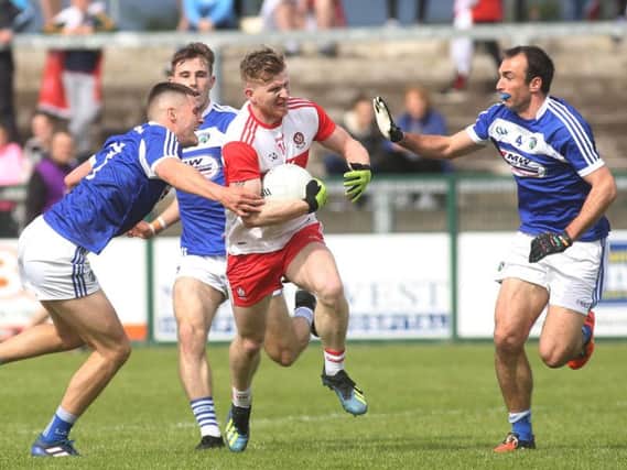 Derry's Enda Lynn with Laois' Patrick O'Sullivan and Gareth Dillon