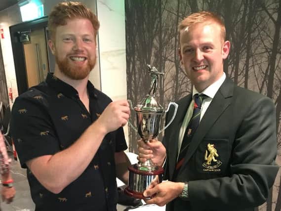 Michael Dempsey, left, receives the Captain's Day trophy from club captain Jonny McDowell.