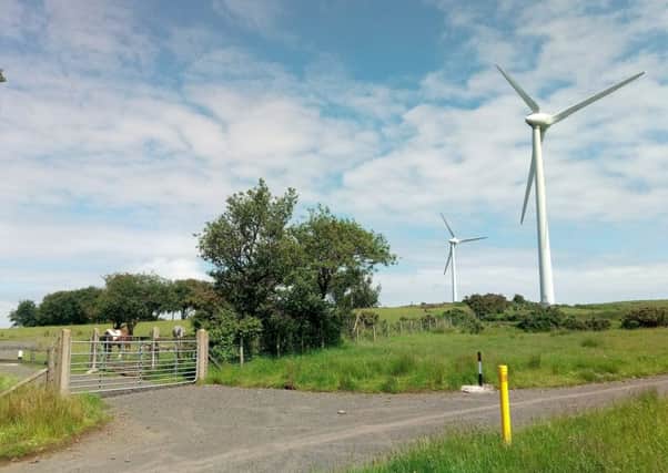 Two of the six turbines at Carn Hill wind farm near Carrickfergus with horses grazing nearby