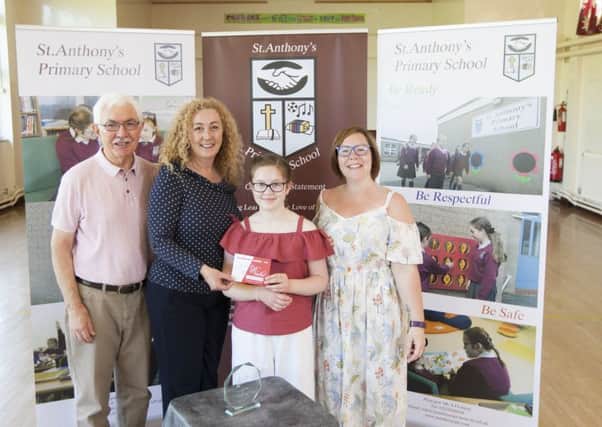 Niamh Reynolds presents vouchers to St. Anthony's principal Aine Fleming which she won at the  Lagan Camerata. Included is chair of the Board of Governors Damien Donaghy and Carol McLarnon, primary seven teacher and school musical director.