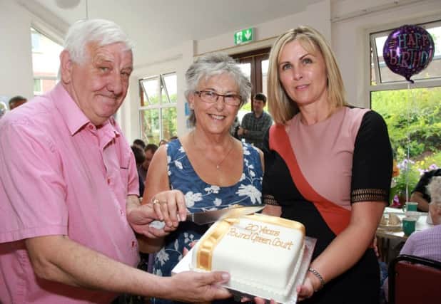 Cutting the 20th anniversary cake are Jeff Shaw, tenant at Pound Green Court, Marlene Smyth, scheme co-ordinator and Carol Ervine, group director of tenant & client services at Choice Housing.