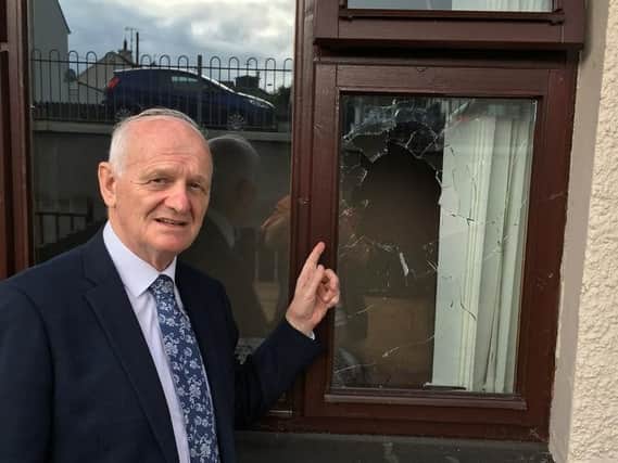 Lord McCrea points to where the rock entered the bedroom window.