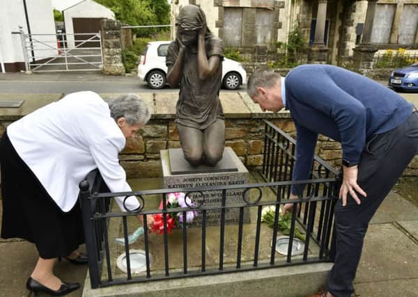 Mary Hamilton and James Miller placing flowers at the Claudy Bomb Memorial on Wednesday morning. DER3119-110KM