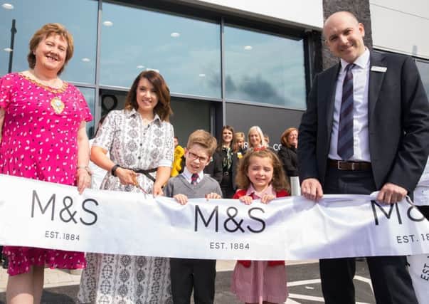 Launching the new M&S store in Carrickfergus is R_L Mayor of Mid and East Antrim Borough Council, Councillor Maureen Morrow, store manager Grace Lough and head of region for M&S Simon Layton. Helping to cut the ribbon is Eva Morrison (5) and Oscar Millar (6) from Carrickfergus Model Primary School who were the lucky winners of a colouring competition.