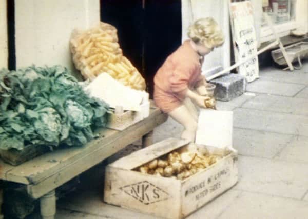 Kathryn Eakin filling a bag of potatoes outside her family store in Claudy where she was later killed by an IRA bomb, aged eight. (M McLaughlin).