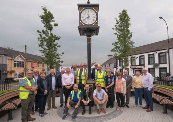 Representatives from Mid and East Antrim Borough Council, Ahoghill Traders' Association and volunteers and the new clock in Ahoghill.
The traditional chimes of Big Ben will now ring through Ahoghill following the installation of a new village clock. The £90,000 project, which included the new clock and enhancements to the Diamond area, are part of the village renewal scheme. Standing at four metres tall the four sided pillar clock takes pride of place in the heart of the village. Mounted on a steel column and sitting on a granite raised plinth it is a real focal point for visitors and locals.