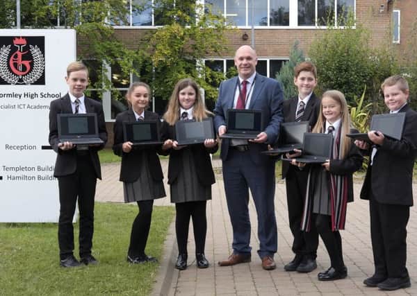 Mr Massey and pupils showcase some of the new computers.