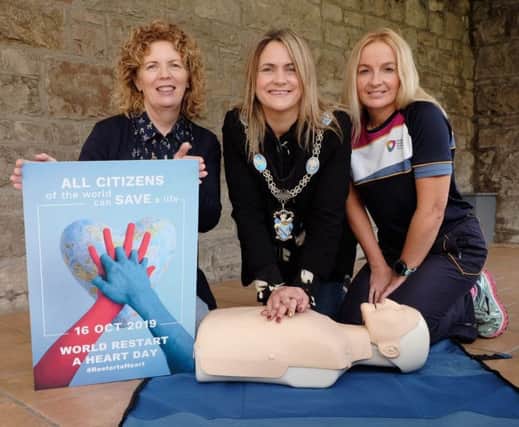 Lord Mayor of Armagh City, Banbridge and Craigavon Mealla Campbell learns how to administer CPR by Investing for Health Officers Elaine Devlin and Cathy Devlin