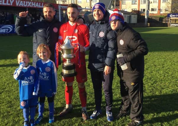 Hanover captain James Sergeant with the Bob Radcliffe Cup trophy in 2017. Also included are, back row from left, Steven Hyndes (manager), Dean Crowe (assistant manager) and Dean Wilson (team attendant), plus young fans Taylor Crowe (left) and Olly Hyndes.