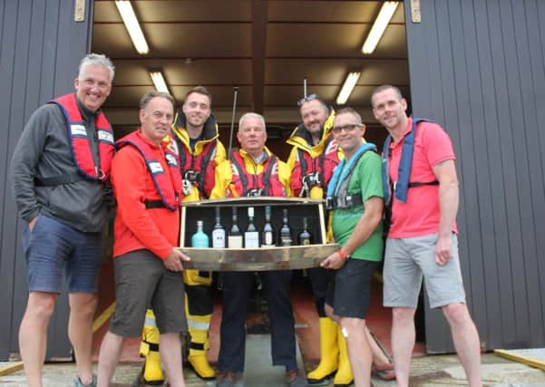 The rowing team with members of Portrush RNLI with the whiskey and cask