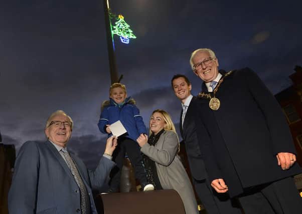 Rylee Stevenson gets to see his winning design in lights and receive his prize from Alderman Allan Ewart MBE, Chairman of the council's Development Committee.  Also pictured are his mum Daneka; David Burns, Chief Executive and the Mayor, Councillor Alan Givan.