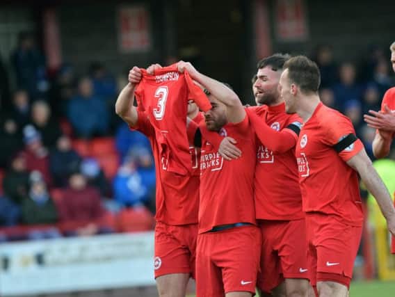 Davy McDaid celebrates his opener for Larne with a tribute for former player Jerry Thompson
