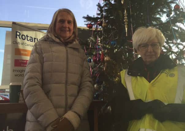 Rotarians Gillian McCallion and Mary Sinnamon take their turn collecting at the tree.