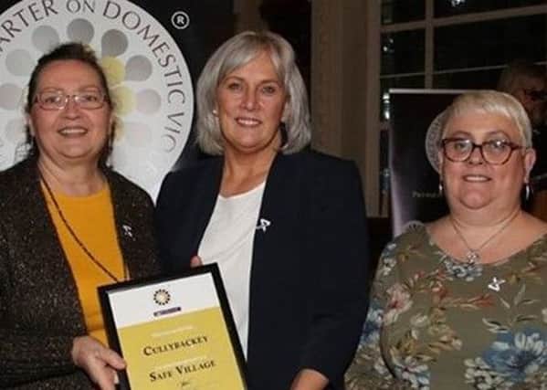 Oonagh Dalton (first left) received her award from Paula Hillman of the Police Service of Northern Ireland, watched on by Coleen Christie of Cullybackey Methodist Church.]