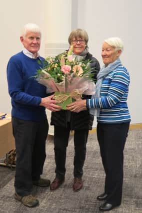 Libby Henry (chairperson) and Bruce Holdstock  (vice-chairperson) presenting a bouquet of flowers to Jennie Watt, the 200th person to join the Ballymena U3A this year.