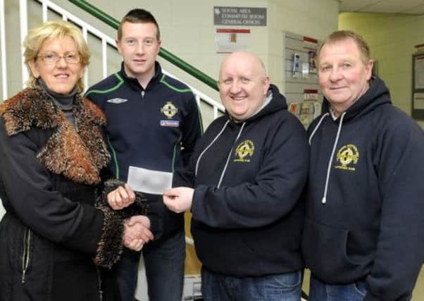 Norah Beare was presented with a cheque for £50:00 by 1st Dromore Northern Ireland Supporters Club members Gareth Neil, Chairman Steven Mawhinney and Brian Lindsay the money will be used to get a seat in memory of the late Helen McFadden MBE © Paul Byrne Photography INBL11-206PB