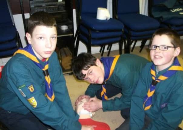 Rhys Taha, Aaron Cunningham and Ryan Cryan from 7th Larne Scouts
practise CPR at the South East Antrim Scout first-aid competition. INLT 11-659-CON scout6.
