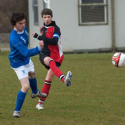 Foyle Wanderers under-16's captain Ross Wylie clears the ball under pressure from a Trojans striker. INLS1113-194KM