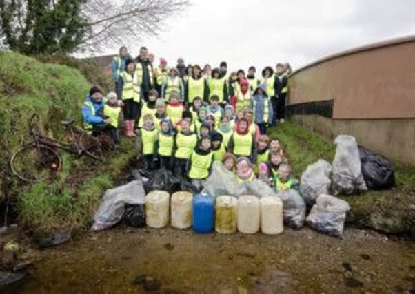 Pupils from Craigbrack Primary who helped clean up Castle River in Eglinton with officers, teachers and some of the rubish they removed.