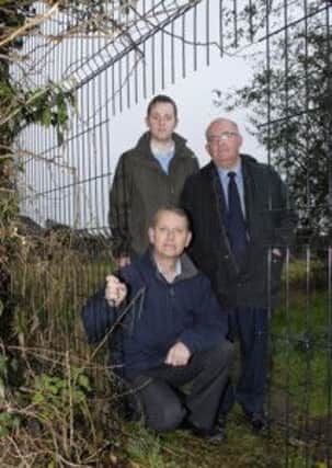 Alderman Maurice Devenney, Councillor Gary Middleton and William Hay MLA, examine the damage to the fence in Eglinton. INLS1113-101KM
