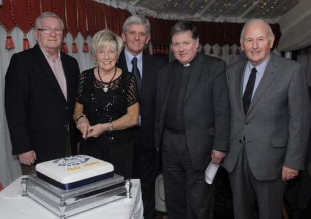 Jeanette Warke pictured cutting the cake to celebrate the 40th anniversary of the Cathedral Youth Club at a function held in the Belfray Country Inn on Friday night. Included are, from left, Bill McBride, Liam Curran, Dean William Morton and Dean Cecil Orr. INLS1213-160KM