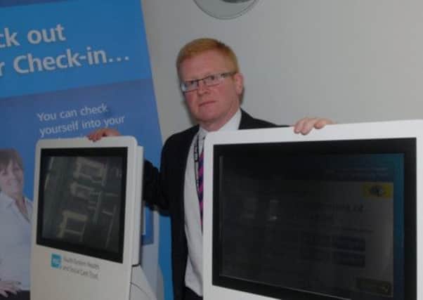 Stephen Stewart with the new automated check in system at the Outpatients Department at Lagan Valley Hospital. INUS1313-LVH