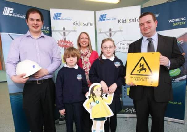 NIE  engineers Keith Houston (l) and Michael Boyle (r) from Banbridge with NIE Safety Officer Julie McDowell and pupils Sam Turkington and Abbey Taggart at the launch of Northern Ireland Electricity's Kidzsafe campaign.
