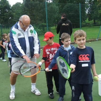 Ballymena Lawn Tennis Club chairman Fergus Barklie passes on some coaching tips to some of the club's youngest players.