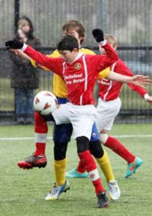 Carniny U-13 player Shan Elliott shields the ball from his Dungannon opponent during their match at Ballymena Showgrounds. INBT13-238AC