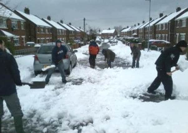 Community spirit: This picture sent in by Andrew Millar shows residents of Derrymore Avenue, Glengormley who worked for more than four hours to clear snow from their street at the weekend. INNT 13-535CON